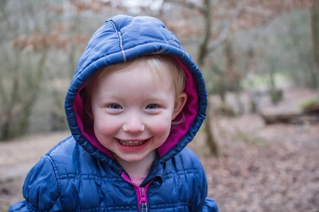 My toddler and her cheeky grin for the camera in epping forest