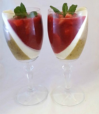 Unas copas con capas inclinadas de kiwi, fresas y yogur griego