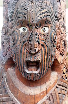 Close up of a maori carving of a face.