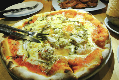 A pizza full of cheese and seafood and the sauces look delicious