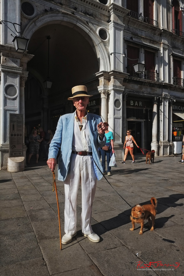 Classic Italian menswear for summer, panama hat, linen jacket and trousers, a cane, a dog and a cigar. Piazza San Marco, Venice. Photographed for Street Fashion Sydney by Kent Johnson. Classic Italian menswear for summer, panama hat, linen jacket and trousers, a cane, a dog and a cigar. Piazza San Marco, Venice. Photographed for Street Fashion Sydney by Kent Johnson.
