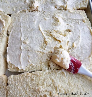spreading mayo mixture over roll bottoms