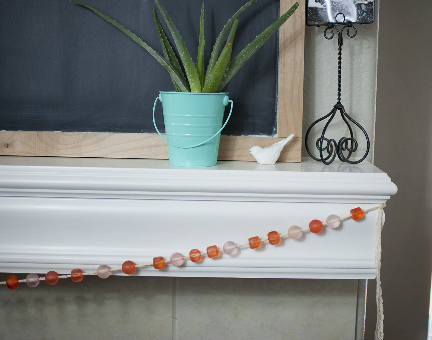 Coral and Pink Glass Bead Garland On White Fireplace Mantle