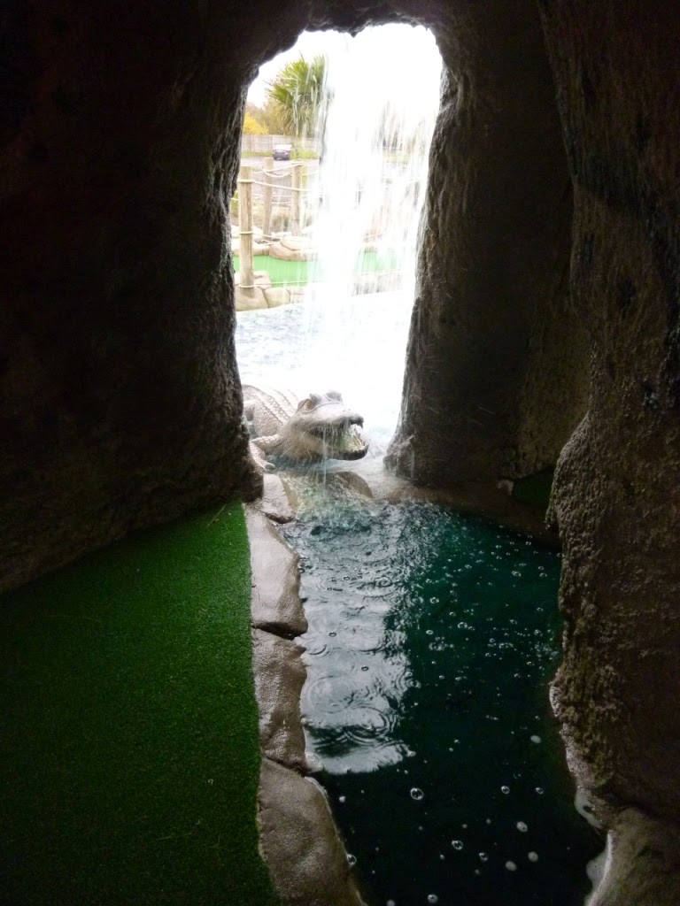 A croc emerges from the water at the Jungle Island Adventure Golf course at Horton Park Golf Club in Epsom, Surrey