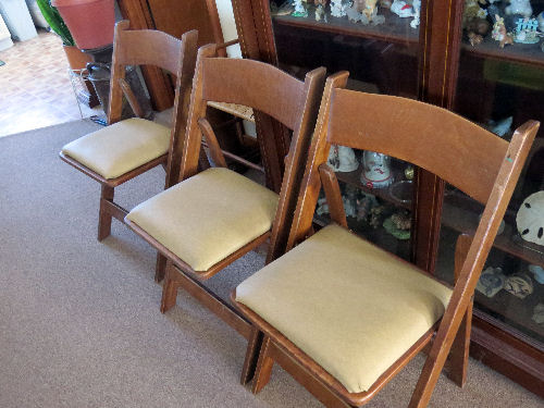 three wooden folding chairs