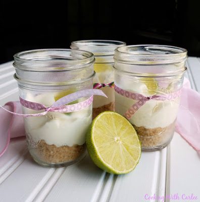 These cute little key lime cheesecakes only take 6 ingredients and just a few minutes to make. They are a perfect individual dessert that travel well. Make a batch for your next party! jars filled with key lime pie cheesecake mixture with ribbons and a lime
