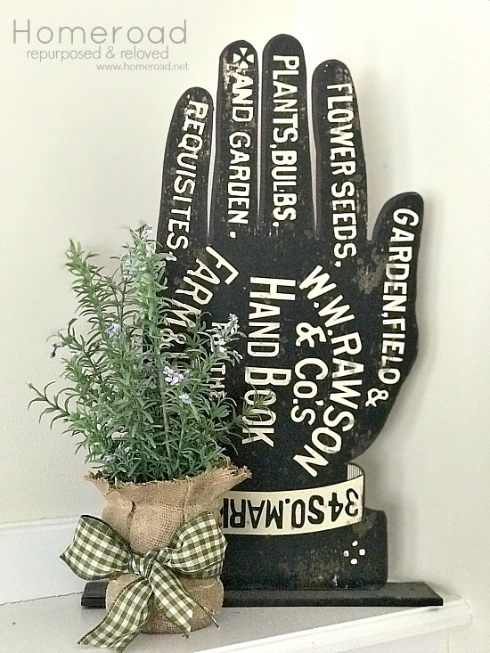 Metal garden hand with burlap vase and plant