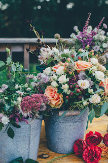 Photo by Annie Spratt on Unsplash Two metal buckets filled with a variety of multi-colored flowers. Photo by Annie Spratt on Unsplash.