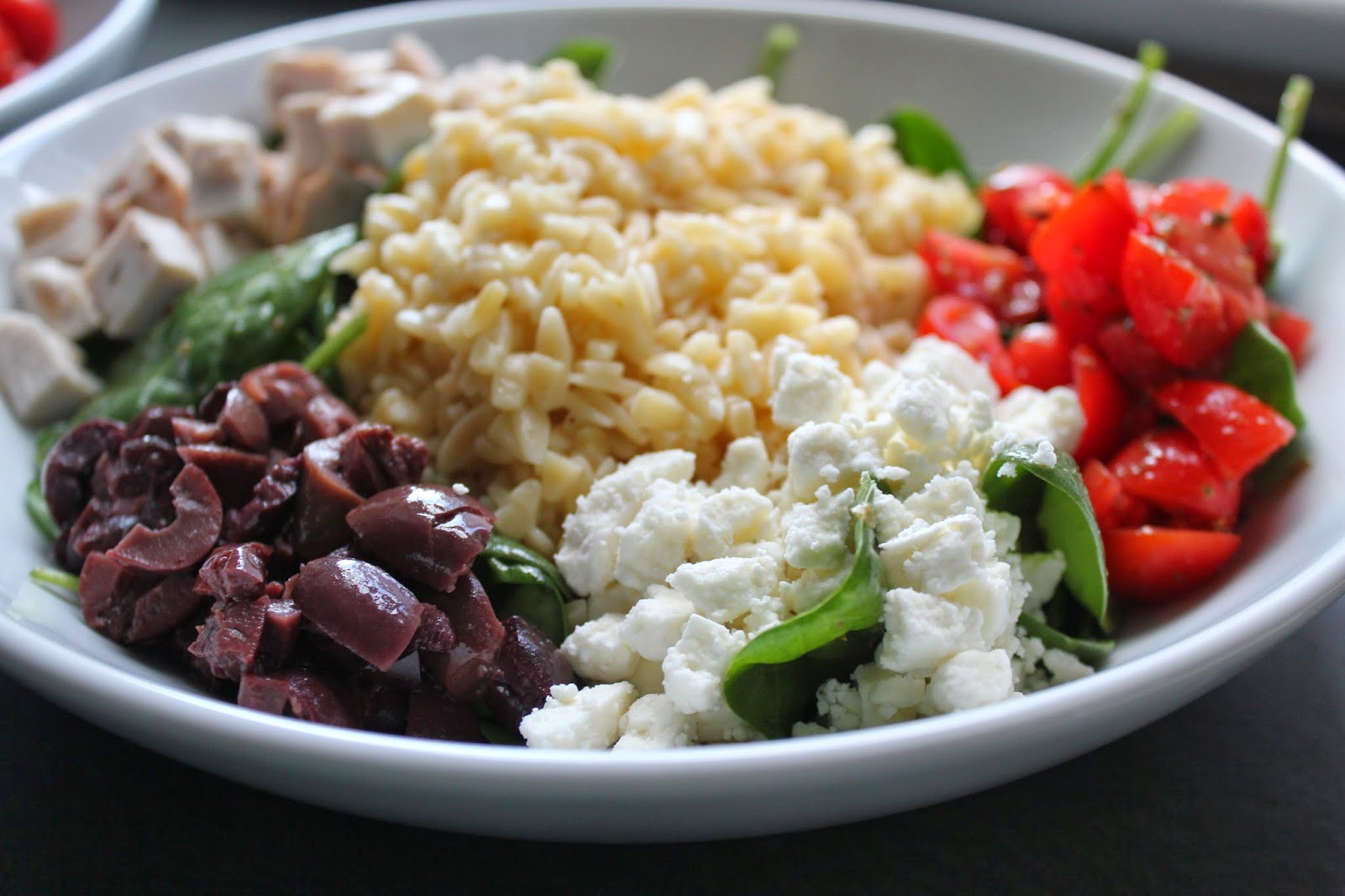Spinach, orzo, tomatoes, olives, chicken, and feta for Greek chicken and orzo bowls
