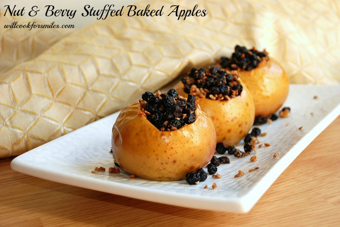 3 baked Apples stuffed with berries and nuts on a long white plate 