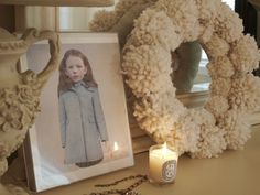 Pom pom wreath, Diptyque candle, and Loretta Lux print on dresser
