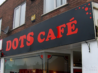 Fascia of Dots Café in a bold red font. In the corner are little dots of red.