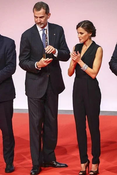 Queen Letizia wore HUGO BOSS V neck jumpsuit with satin trims. Magrit pumps, diamond earrings and baracelet