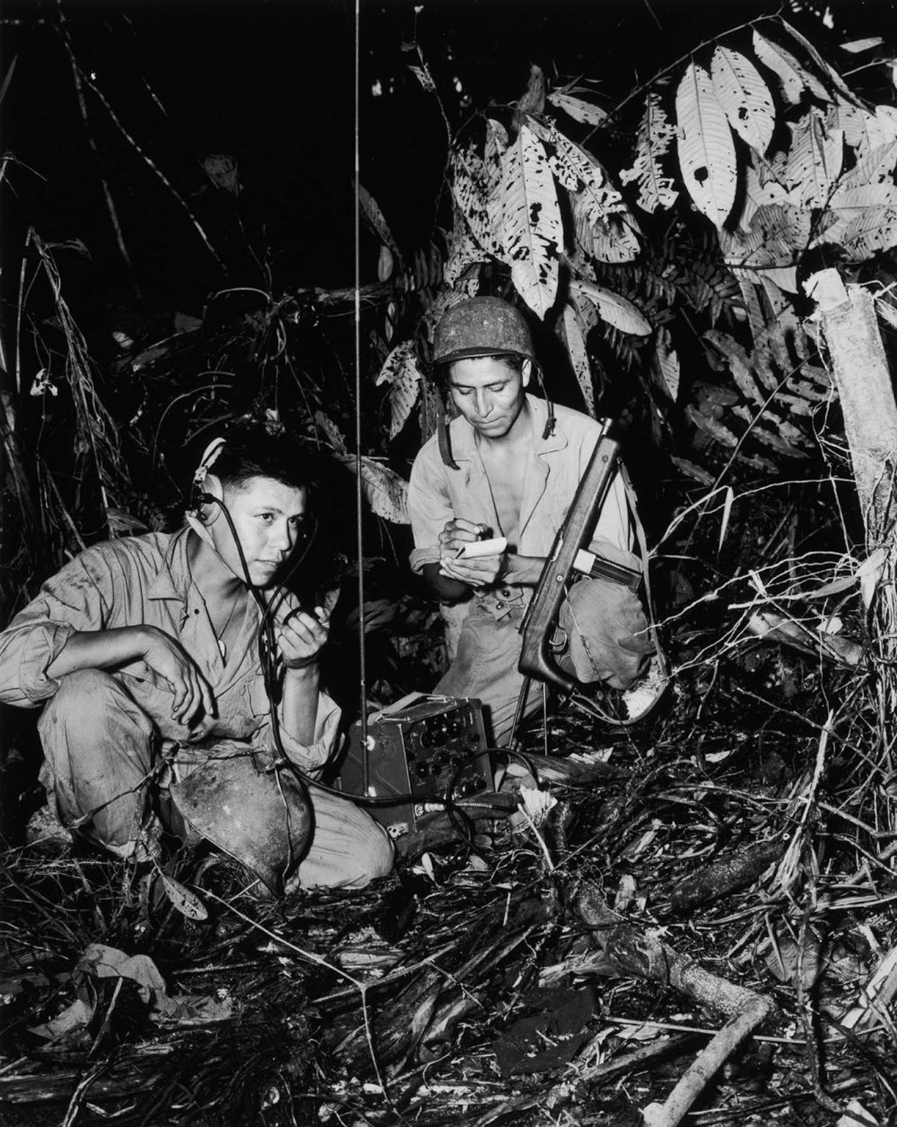 Navajo code talkers Cpl. Henry Bake, Jr. and PFC George H. Kirk transmit messages during combat on Bougainville. 1943.