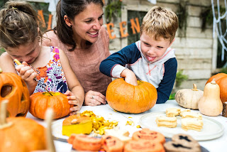 Mother Bonding with son and daughter while carving pumpkins