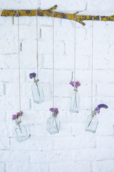 Rama con botellas de cristal y flores