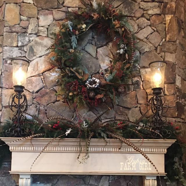 Rustic lodge mantle piece and wreath with greenery and feathers