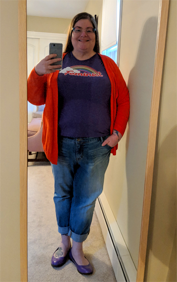 image of me, a fat white middle-aged woman with long brown hair and glasses, standing in a full-lenth mirror wearing a purple t-shirt with a rainbow that says 'Feminist', a red cardigan, skinny-cut blue jeans, and purple Doc Martens slip-ons