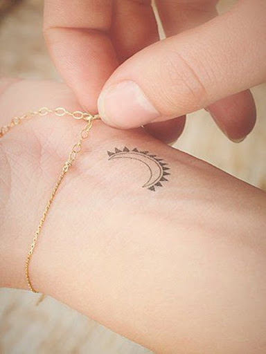 Uma lua crescente é acentuado com triângulos nesta peça simples retratado na portador de pulso.