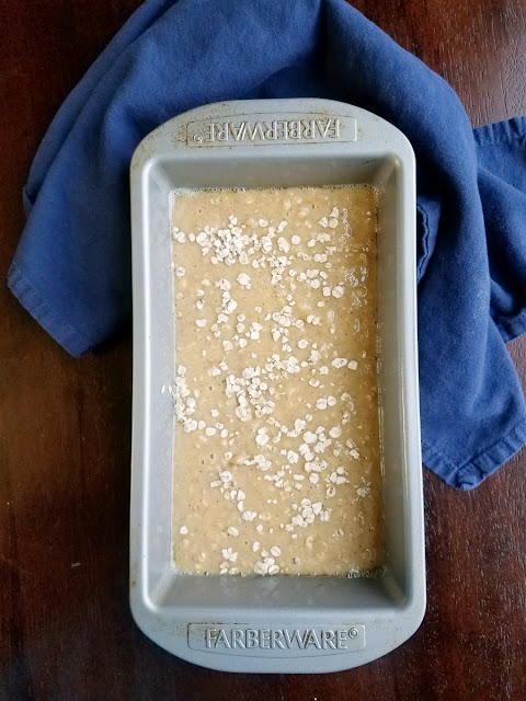 Applesauce oatmeal bread is a delicious sweet quick bread that's perfect for breakfast, tea time, snack or even a light dessert. The vanilla honey butter helps take to the next level of yumminess! applesauce oatmeal bread batter in bread pan with oatmeal sprinkled on top