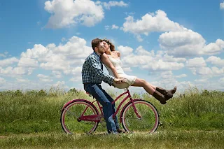 a couple in a relationship on a bike kissing 