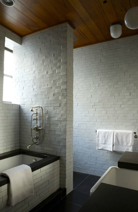Wooden ceiling and white brick walls in this bathroom designed by Fernando Santangelo via Remodelista.