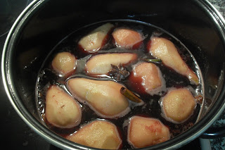 Cociendo las peras con el vino tinto especiado.