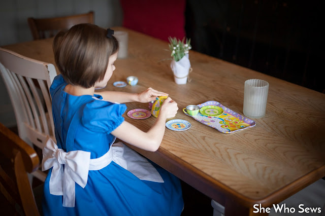 Alice in Wonderland Tea Party Girl in blue dress playing with her teaset