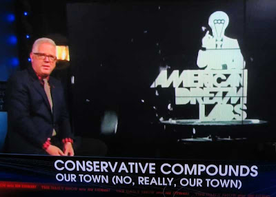 Glenn Beck sitting at left of screen with graphic on a screen in background reading AMERICAN DREAM LANDS with a male figure in a suit over the words