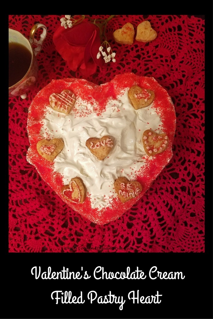 this is a chocolate heart cream pastry filled with chocolate pudding, whipped cream, espresso coffee, a rose and old vintage serving cutter. The photo has the Valentines day  heart shaped dessert  that will be served in a glass bowl  cut up