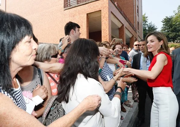 Queen Letizia wore Massimo Dutti Trousers, Carolina Herrera red satin blouse, and Mango perforated design sandals. carried Uterque snakeskin clutch (Summer 2013 collection)