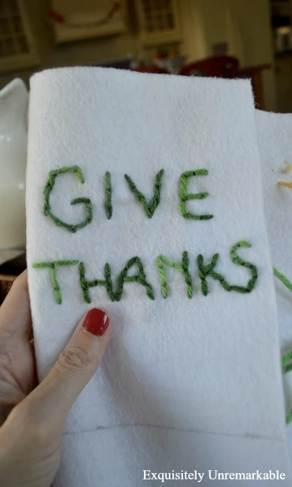 Green give thanks embroidered letters on felt in a hand