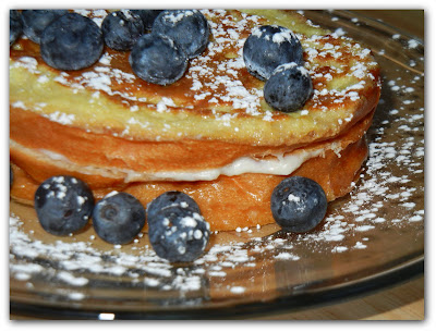 Blueberry and Cream Stuffed French Toast with blueberries around it on a plate 
