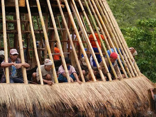 Bentuk dalam dari Rumah suku Wae Rebo. Terlihat para wisatawan lokal sedang bersantai dalam kebersamaan.