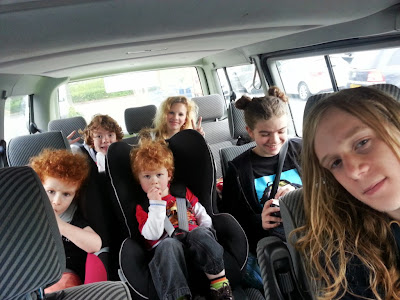 6 children of various ages sitting in the back of a T4 vw transporter van
