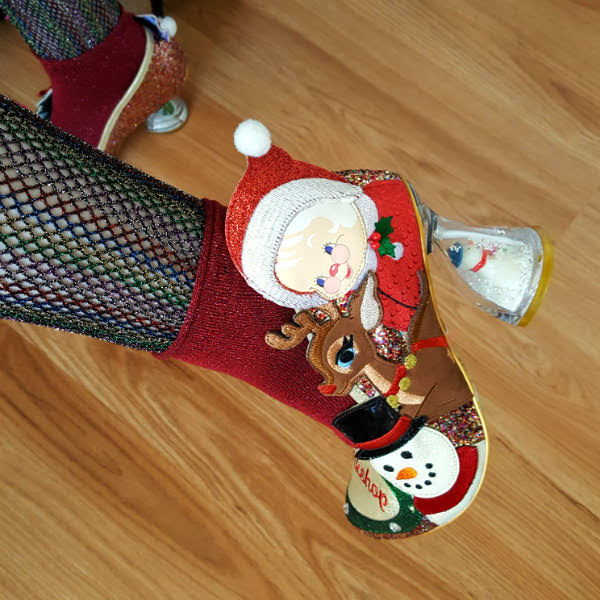 Irregular Choice Mrs Claus shoe with snowman snowglobe heel close up of christmas shoe on foot with mrs claus, snowman and reindeer applique characters and perspex heel with snowman