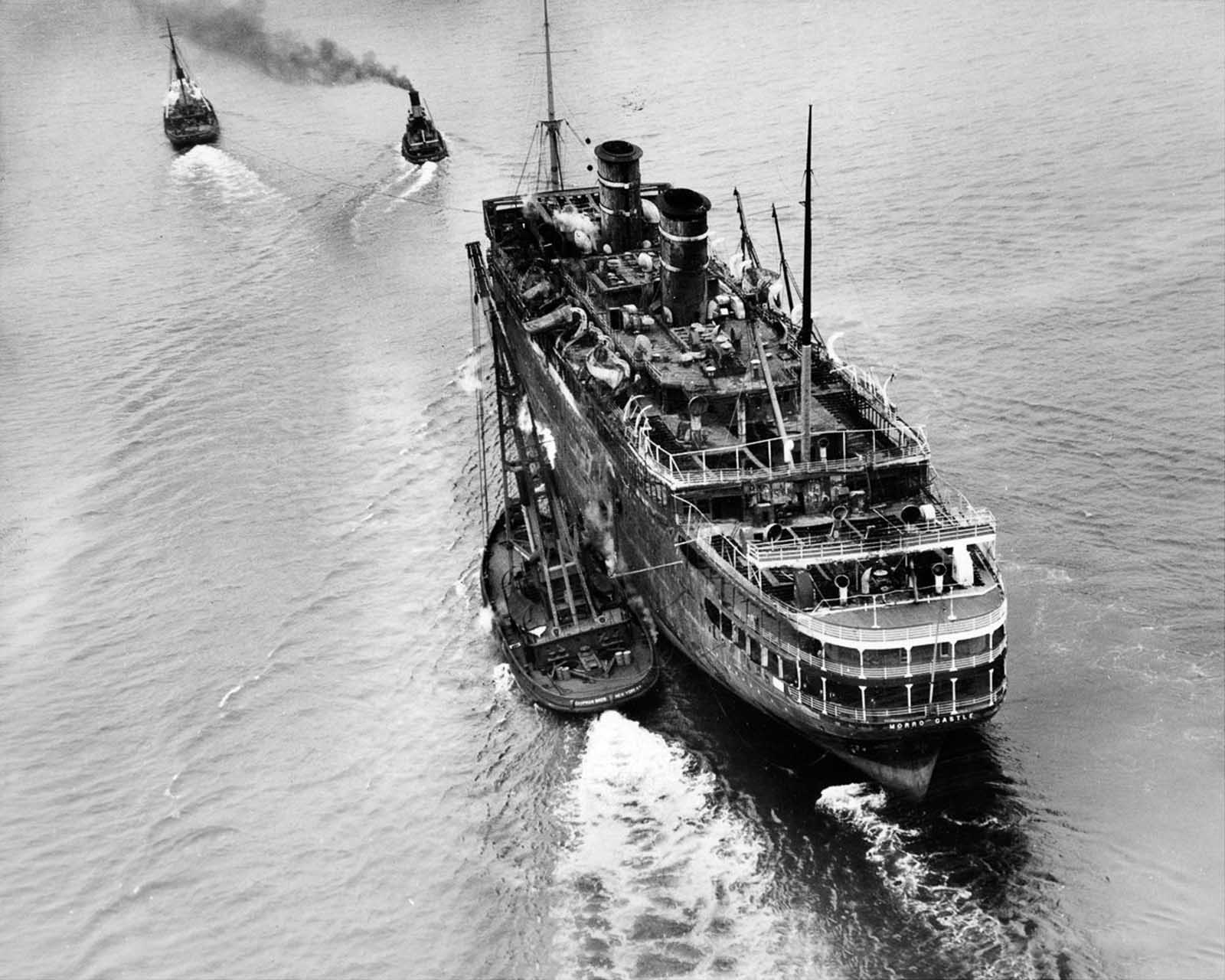 The wreck is towed away to be scrapped, six months after the fire. March 14, 1935.
