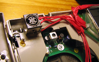 [Image: Another part of the insides of the radio, with the addition of a hotglued Mini-DIN socket.]