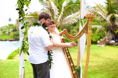 The bride playing the harp as her newly wed husband listen to her