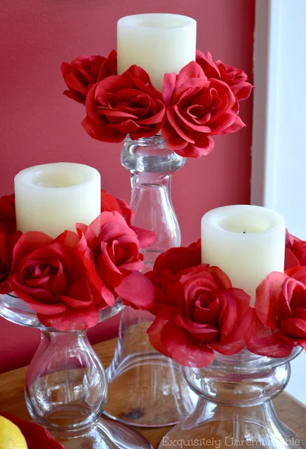 Red Floral Candle Rings on white pillar candle and glass stands