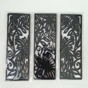 Three laser-cut wooden bookmark-sized black panels with Australian flora designs.
