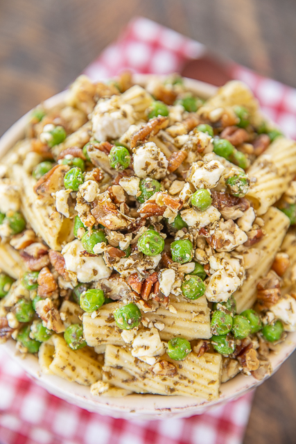 Summer Pesto Pasta Salad - only 5 ingredients! The perfect side dish for all your cookouts and potlucks! Rigatoni pasta, pesto, frozen peas, feta cheese, and pecans. Can make ahead of time and refrigerate until ready to serve. Add grilled chicken or shrimp to make this a main dish! #pesto #pastasalad #sidedish #pasta pesto pasta salad in a bowl
