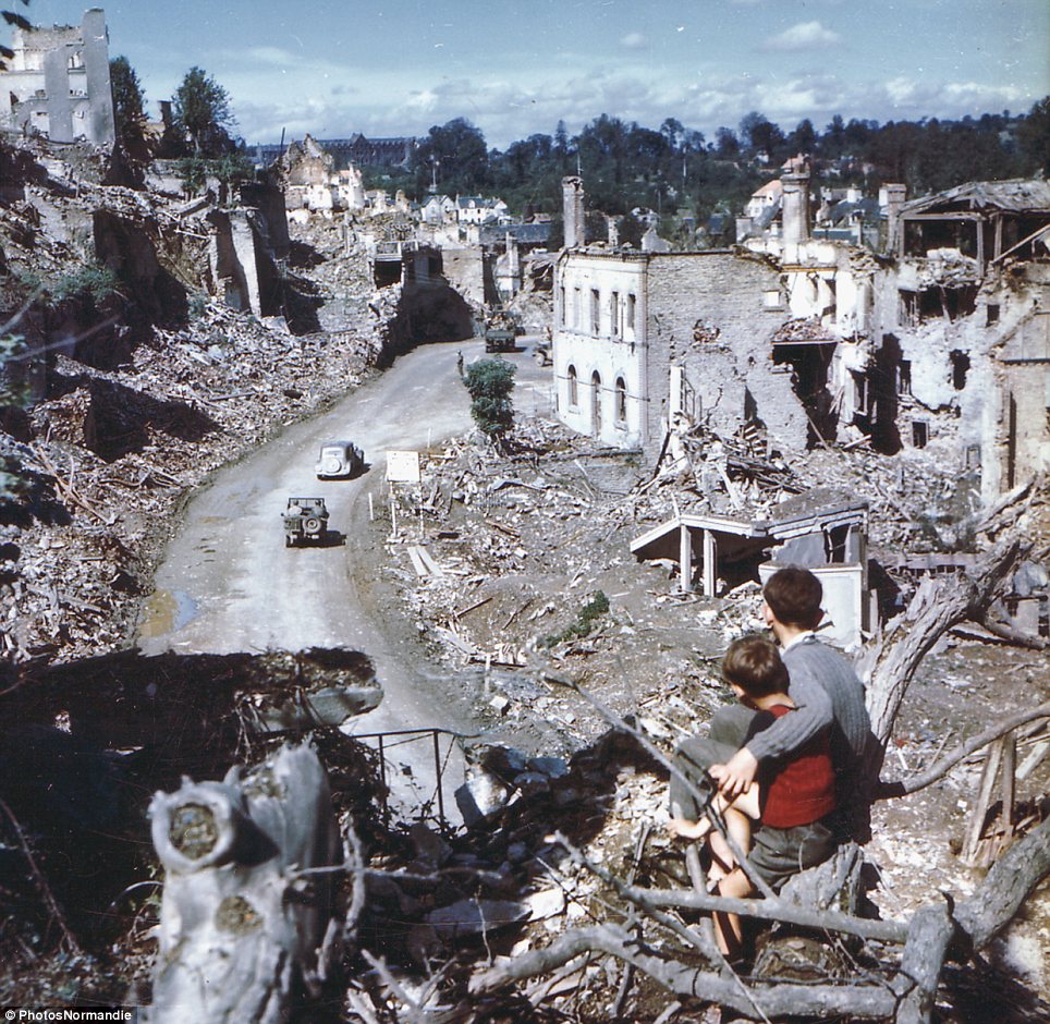 40 Unbelievable Historical Photos - In the aftermath of the D-Day invasion, two boys watch from a hilltop as American soldiers drive through the town of St. Lo. France, 1944.