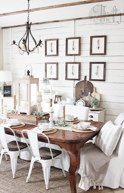 dining room with wood table, white metal chairs, white slipcover chairs, shiplap wall and wood gallery wall.