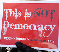sign saying, This is not democracy.  Egypt then Tunisia then Wisconsin then US