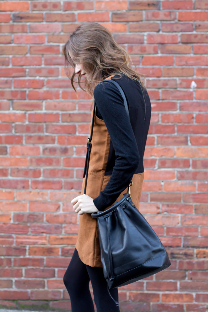Vancouver Style Blogger, Alison Hutchinson, is wearing a tan suede Sanctuary clothing dress, black Vince Ankle boots and a blak leather madewell bucket bag