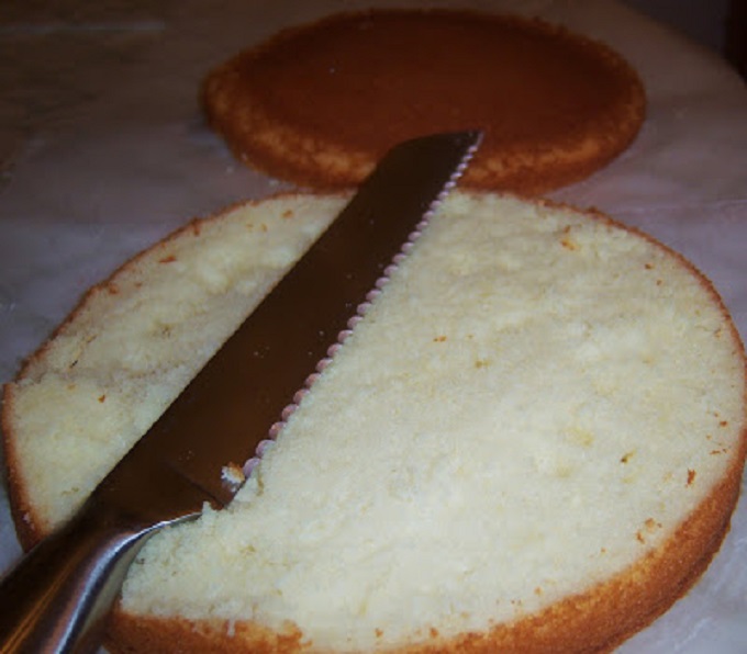 golden yellow cake split in half with a sharp knife while still frozen