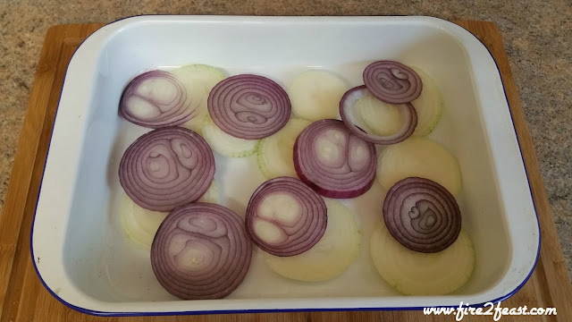 red and white onion sliced in a roasting pan