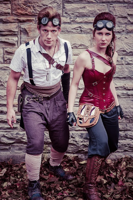 Man and woman wearing steampunk costumes with matching goggles.