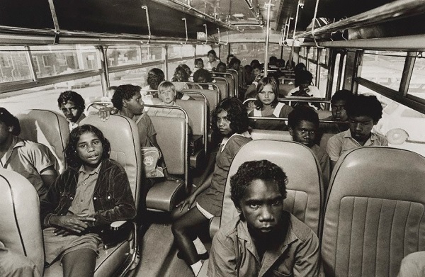 Mervyn Bishop, "School bus, Yarrabah", 1974. Vintage foto: imagen del interior de un camion escolar con niños de varias descendencias, razas.